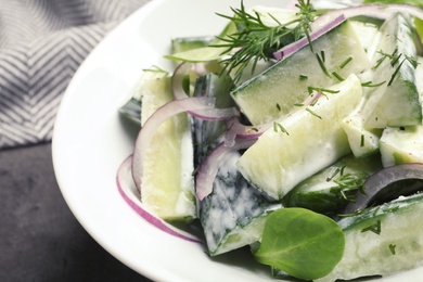 Photo of Plate with creamy cucumber salad on table, closeup