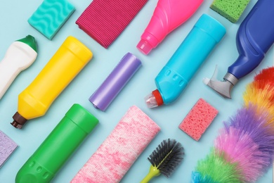 Photo of Flat lay composition with cleaning supplies on color background