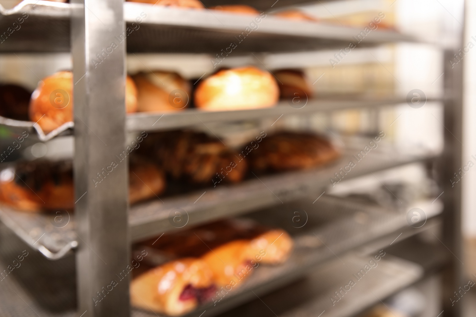 Photo of Blurred view of rack with pastries in bakery workshop