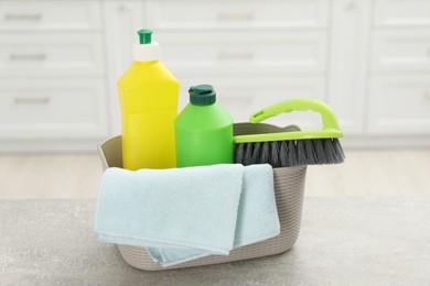 Photo of Different cleaning supplies in basket on table