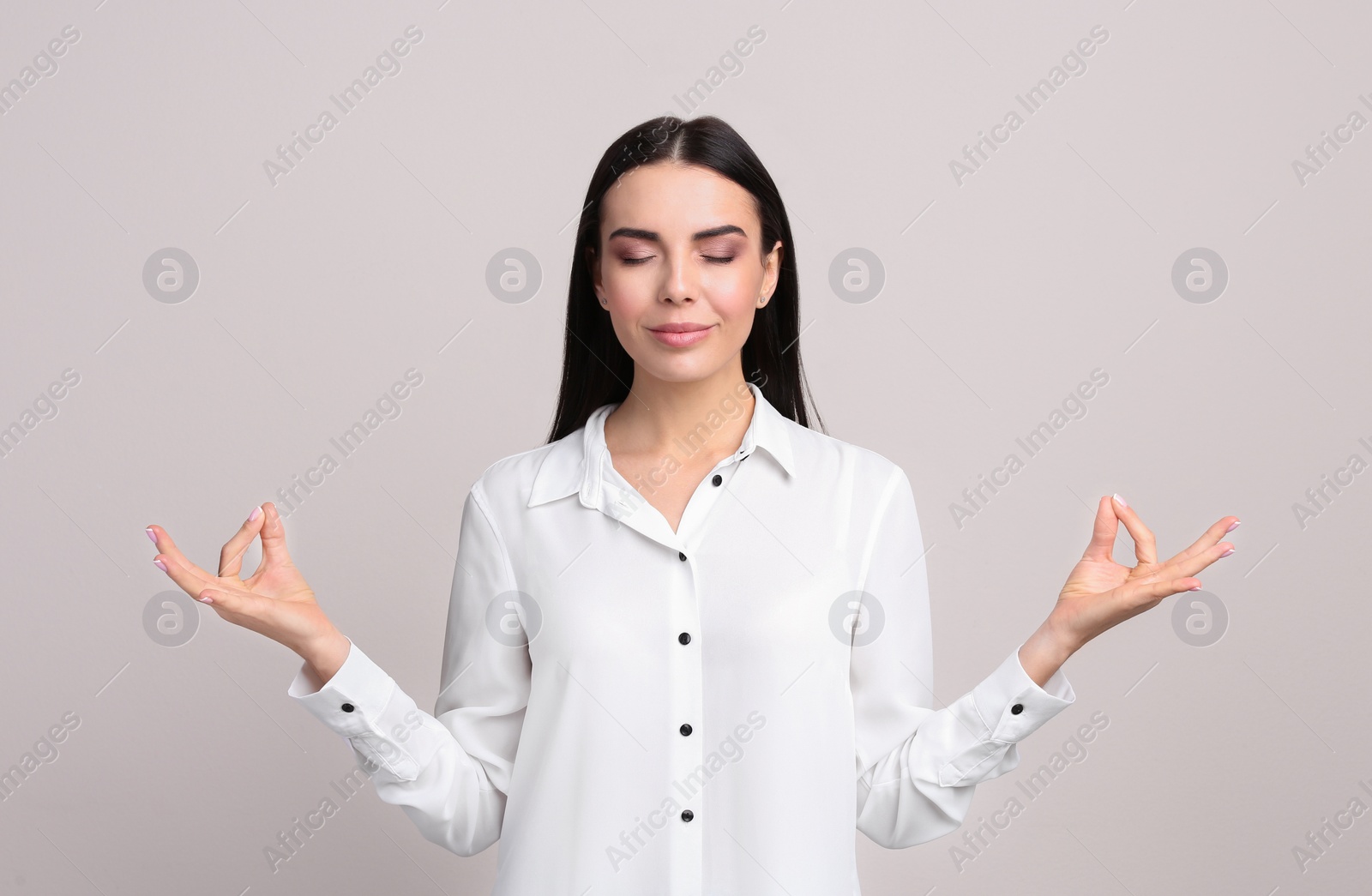Photo of Young woman meditating on beige background. Stress relief exercise