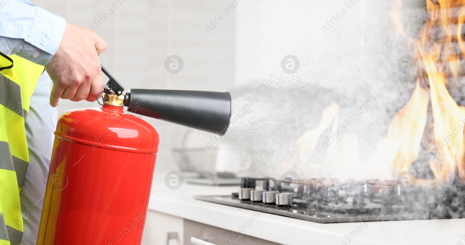 Image of Man putting out burning cooktop with fire extinguisher in kitchen, closeup. Banner design