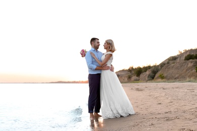 Photo of Wedding couple. Bride and groom standing on beach