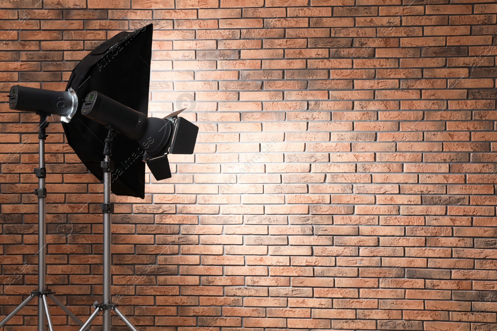 Photo of Professional lighting equipment near wall in photo studio. Space for text