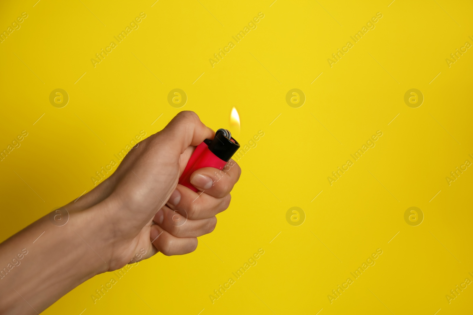 Photo of Woman holding pink lighter on yellow background, closeup. Space for text