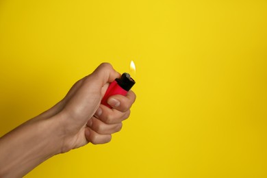 Photo of Woman holding pink lighter on yellow background, closeup. Space for text