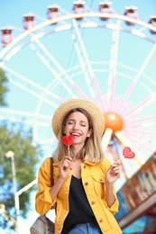 Beautiful woman with candies having fun at amusement park