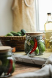 Photo of Jar of pickled cucumbers on wooden table