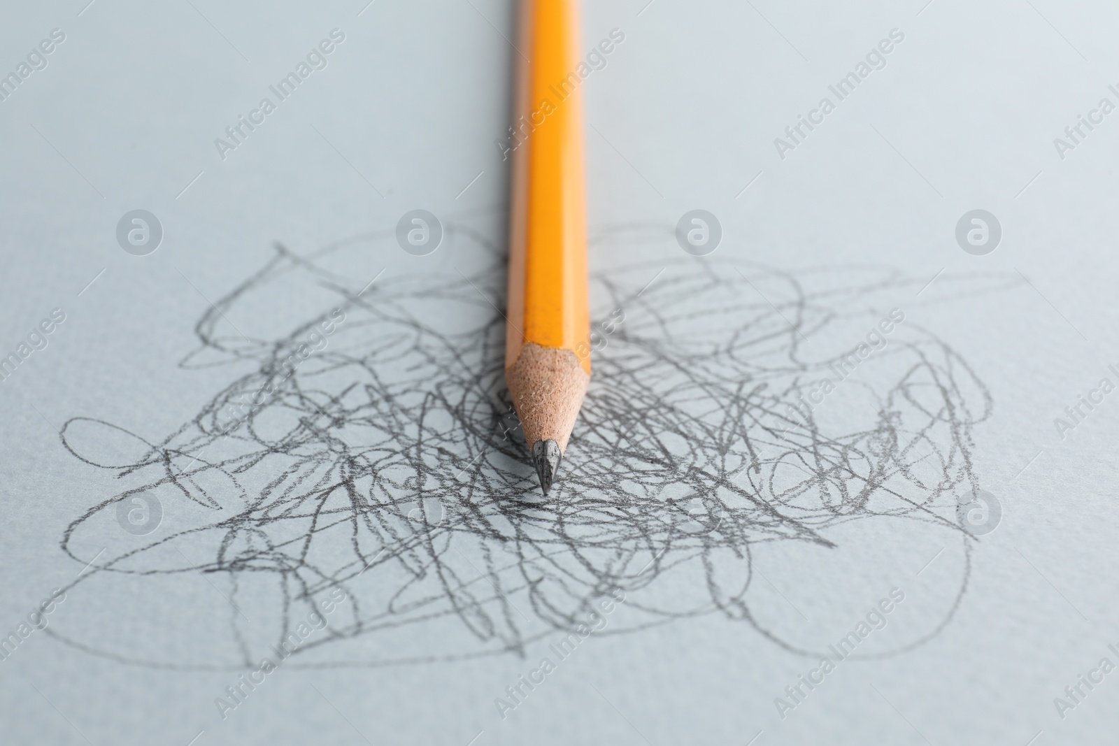 Photo of One sharp graphite pencil and scribbles on white background, closeup