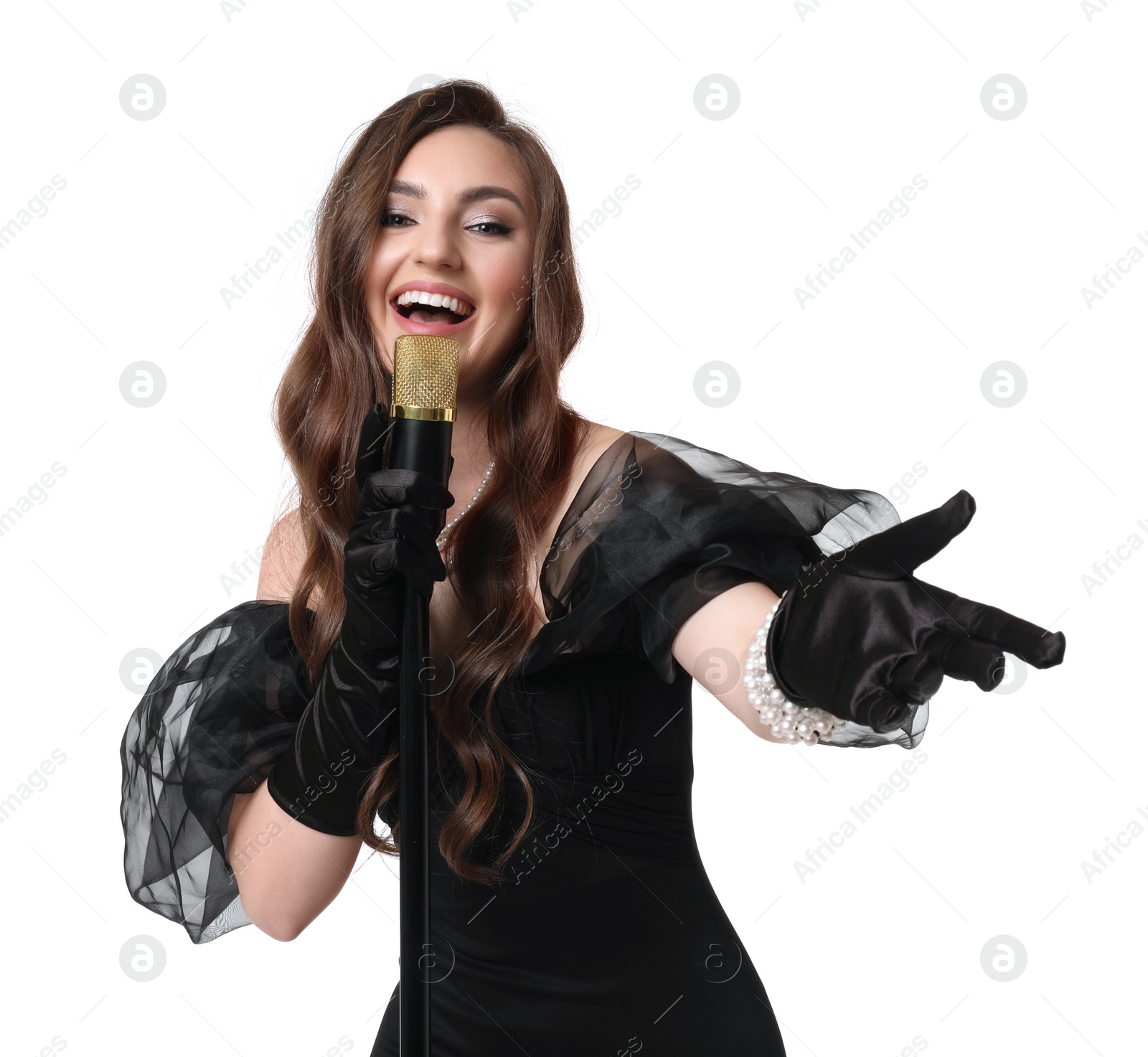 Photo of Beautiful young woman in stylish black dress with microphone singing on white background