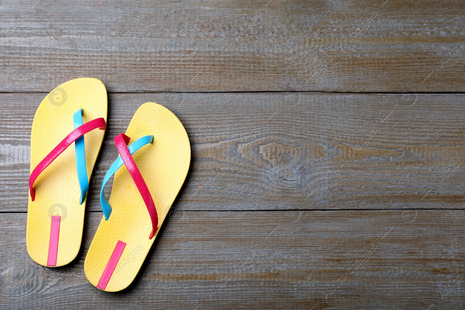 Photo of Stylish flip flops on wooden background, flat lay. Space for text