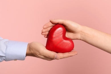Photo of Man and woman with decorative heart on color background, closeup