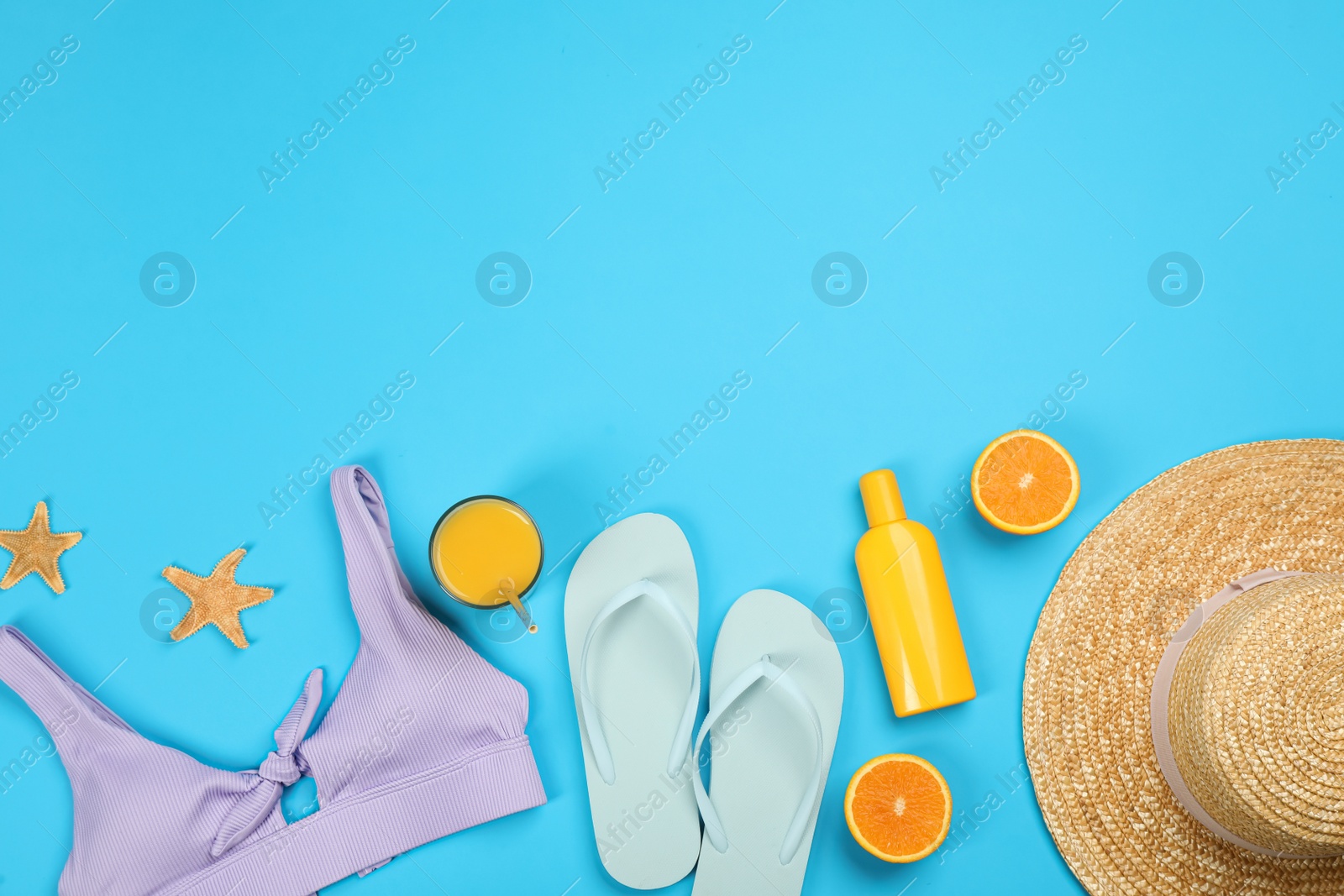 Photo of Flat lay composition with beach objects on light blue background, space for text