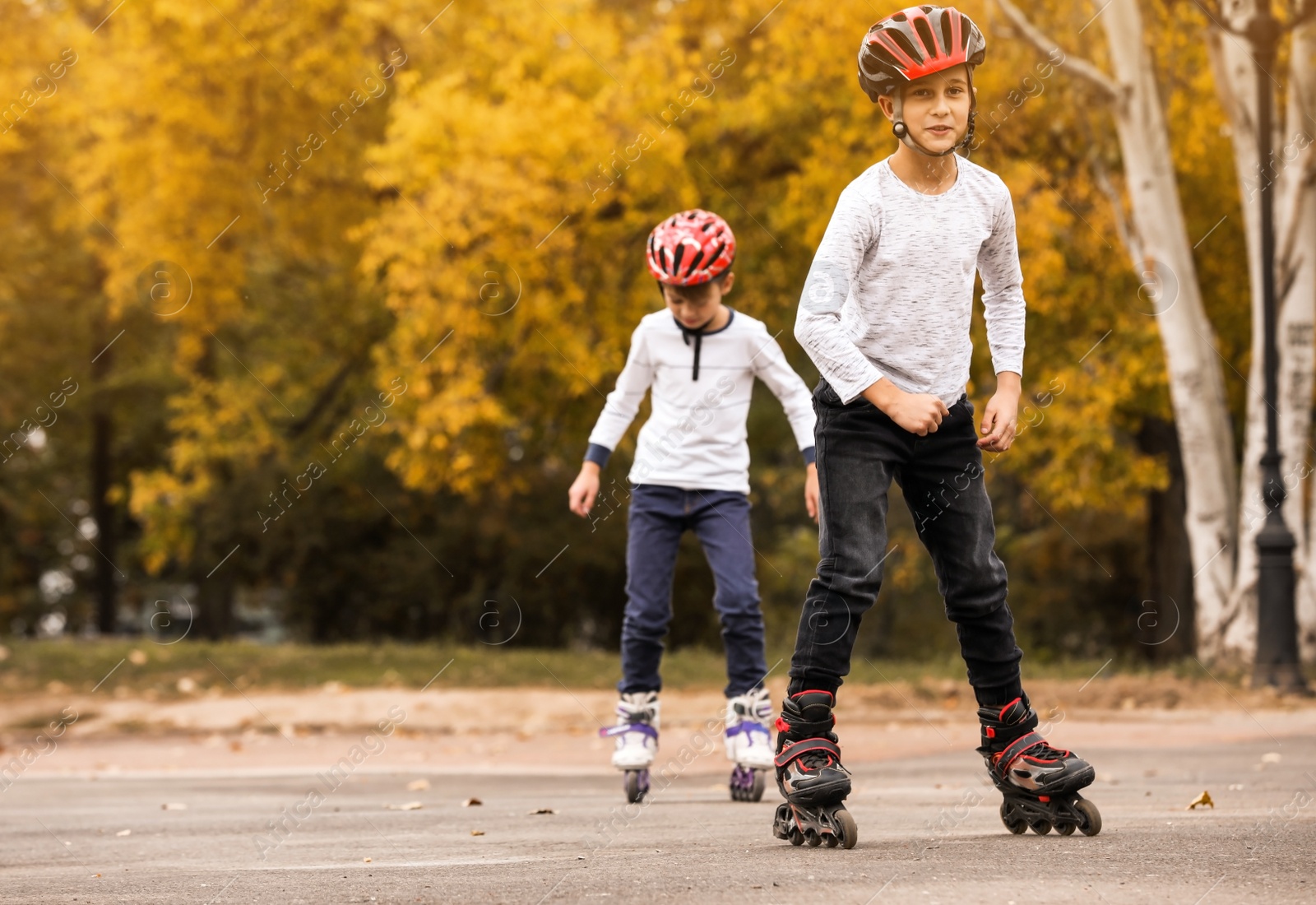 Photo of Happy children roller skating in autumn park