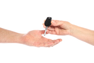 Agent giving car key to man on white background, closeup. Getting driving license