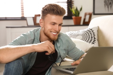 Young man using laptop in living room