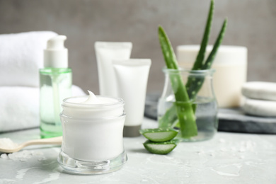 Open jar of aloe cream on grey marble table. Organic cosmetics