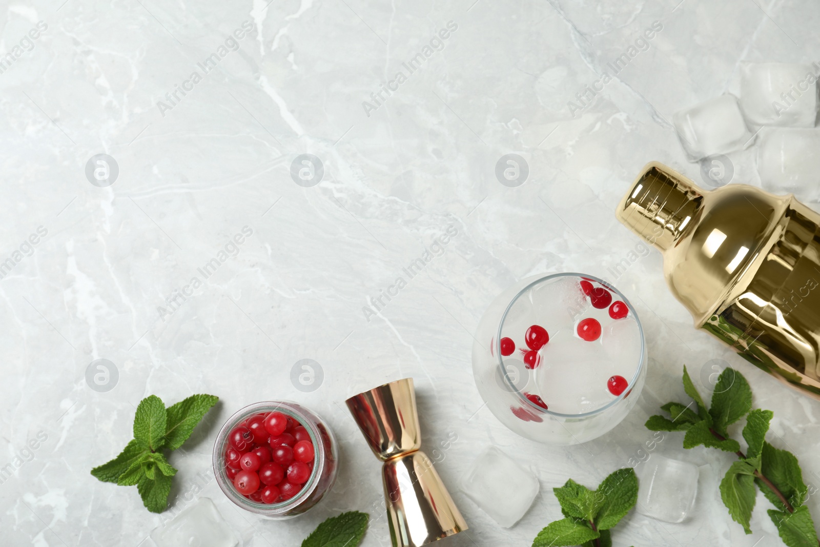 Photo of Flat lay composition of cocktail with vodka, ice and cranberry on grey marble table. Space for text