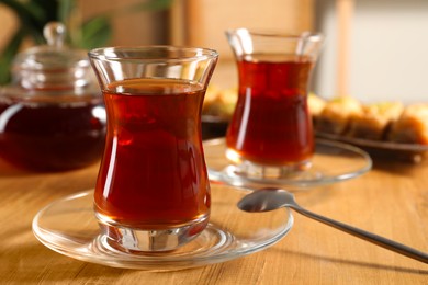 Traditional Turkish tea in glasses on wooden table, closeup