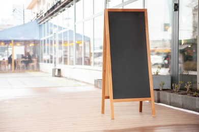 Photo of Empty A-board near building outdoors. Mockup for design