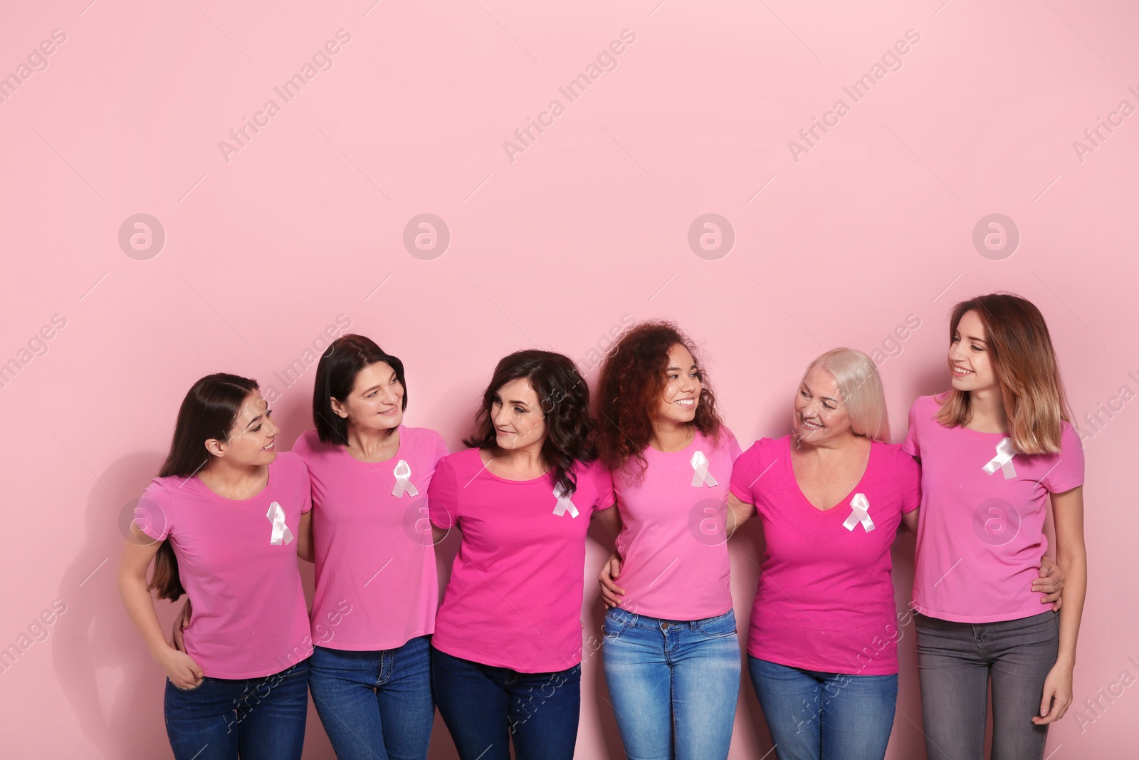 Photo of Group of women with silk ribbons on color background. Breast cancer awareness concept