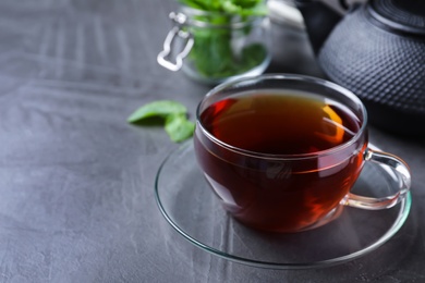 Photo of Fresh tea with mint on grey table. Space for text