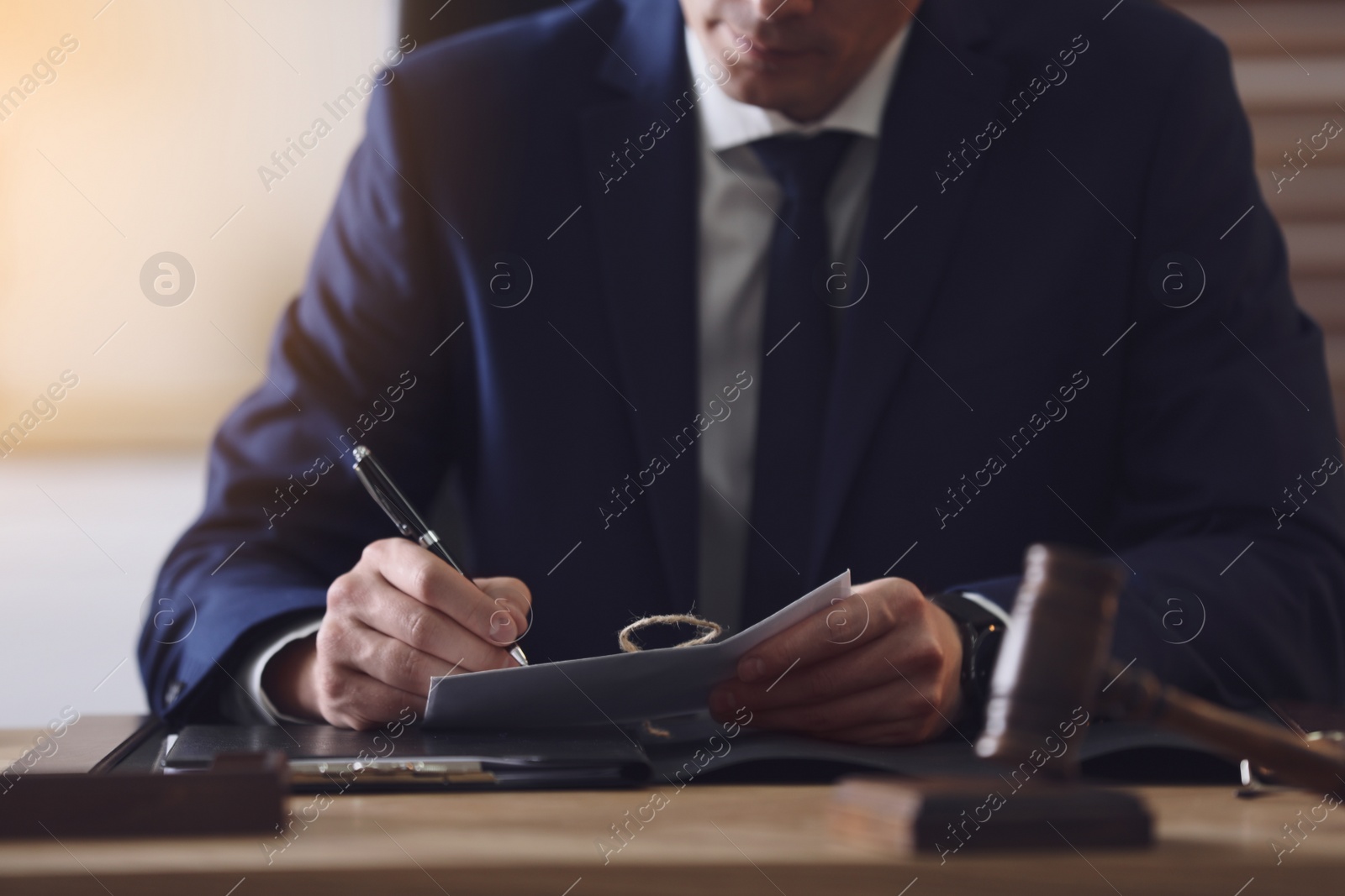 Photo of Male lawyer working at table in office, closeup