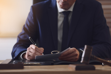 Photo of Male lawyer working at table in office, closeup