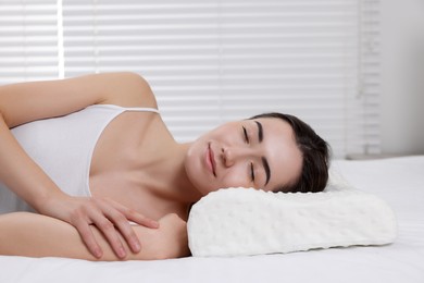 Photo of Woman sleeping on orthopedic pillow at home