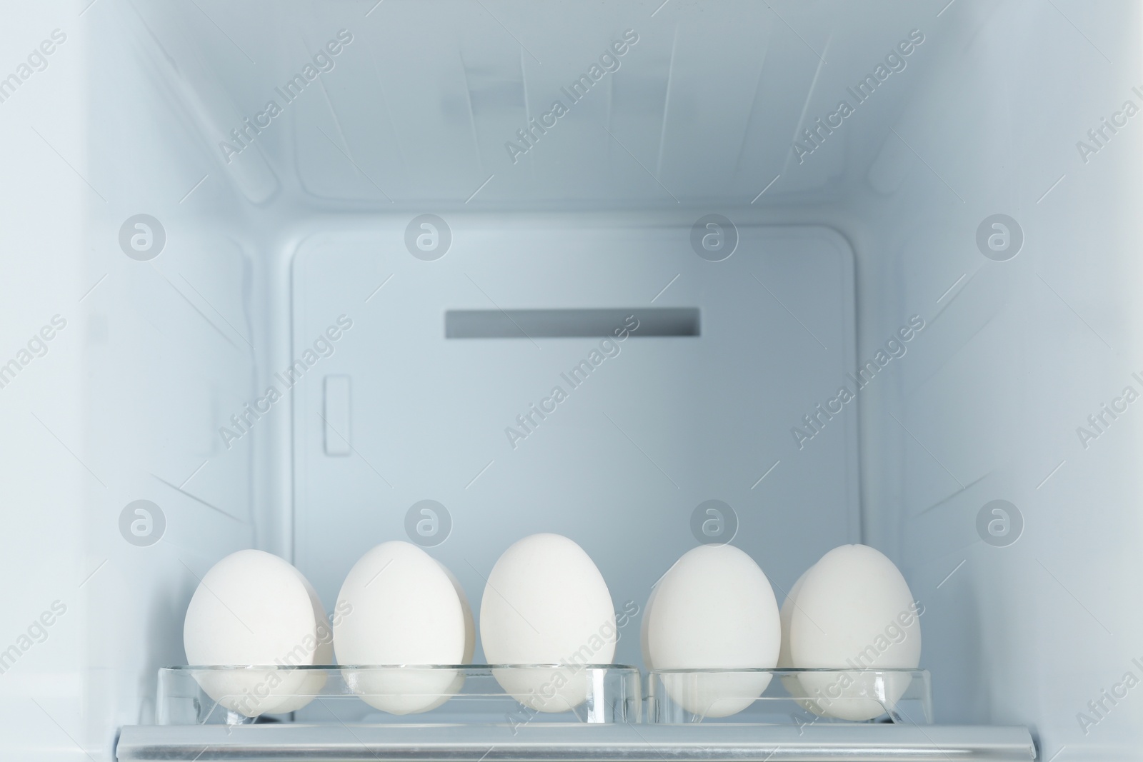 Photo of Fresh eggs on shelf in modern refrigerator