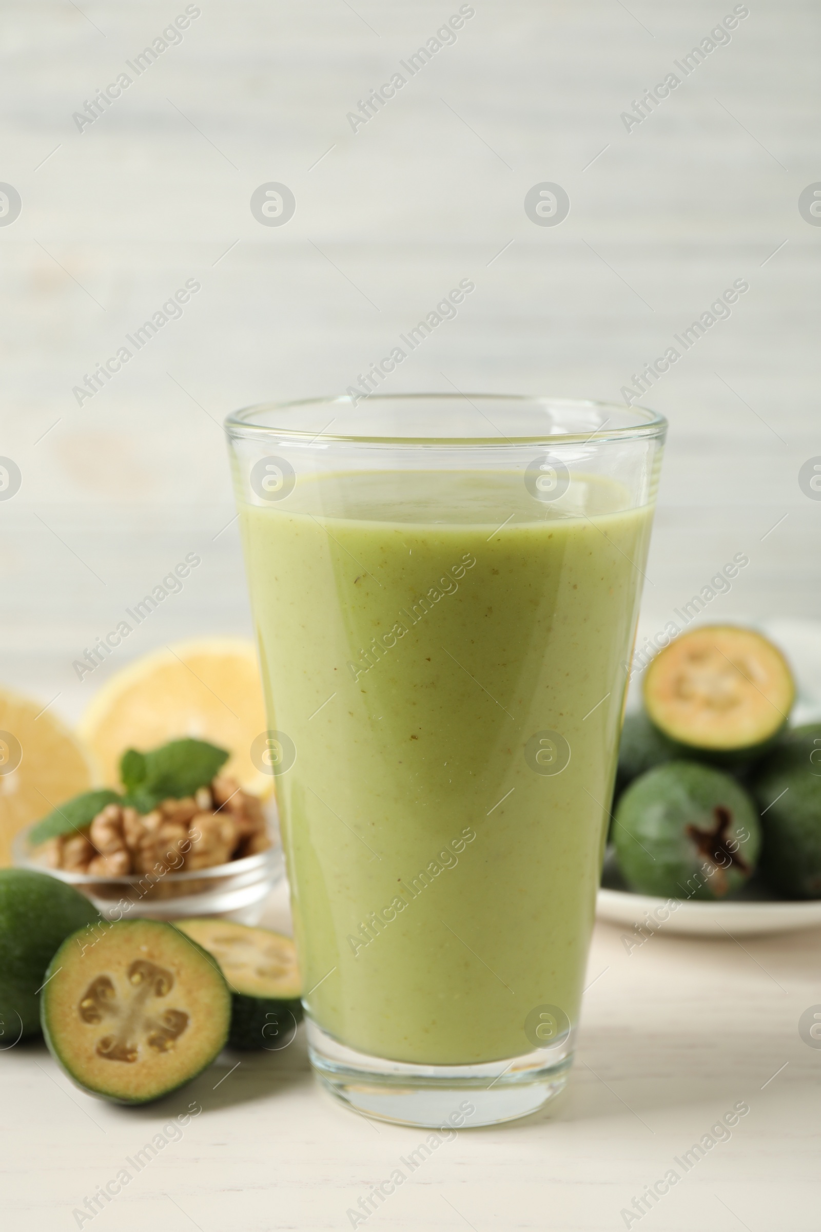 Photo of Fresh feijoa smoothie in glass on white table