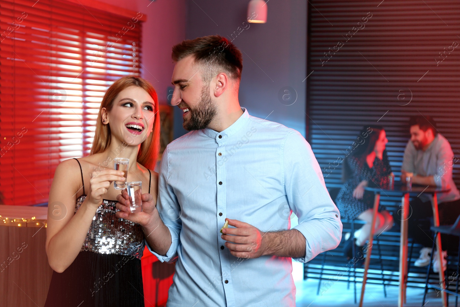 Photo of Young couple with Mexican Tequila shots in  bar