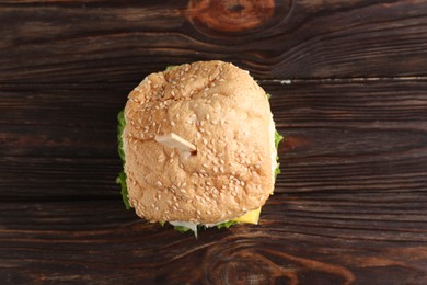 Photo of Delicious vegetarian burger on wooden table, top view