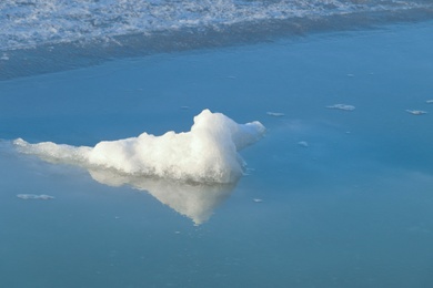 Melting ice in river water on sunny day. Early spring