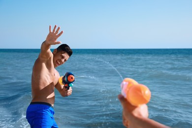Photo of Friends with water guns having fun in sea