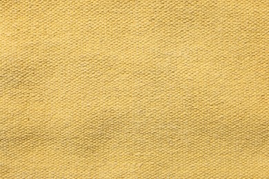 Photo of Texture of soft yellow fabric as background, top view