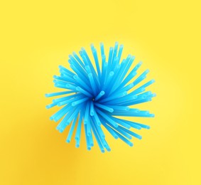 Photo of Blue plastic straws for drinks on yellow background, top view