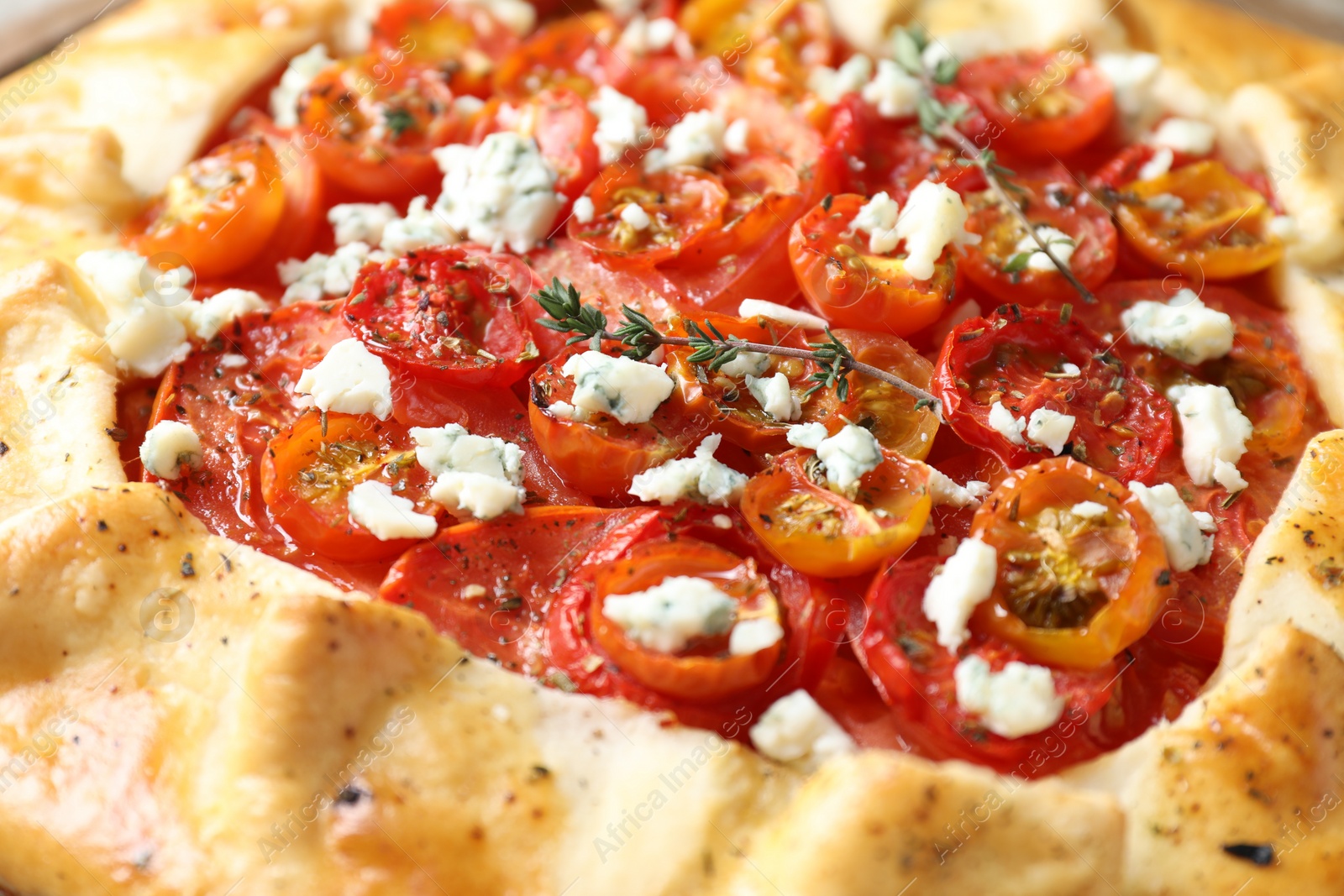 Photo of Tasty galette with tomato, thyme and cheese (Caprese galette) as background, closeup