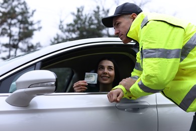 Photo of Woman giving bribe to police officer out of car window