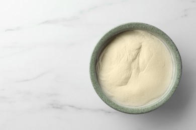 Photo of Bowl of agar-agar powder on white marble table, top view. Space for text