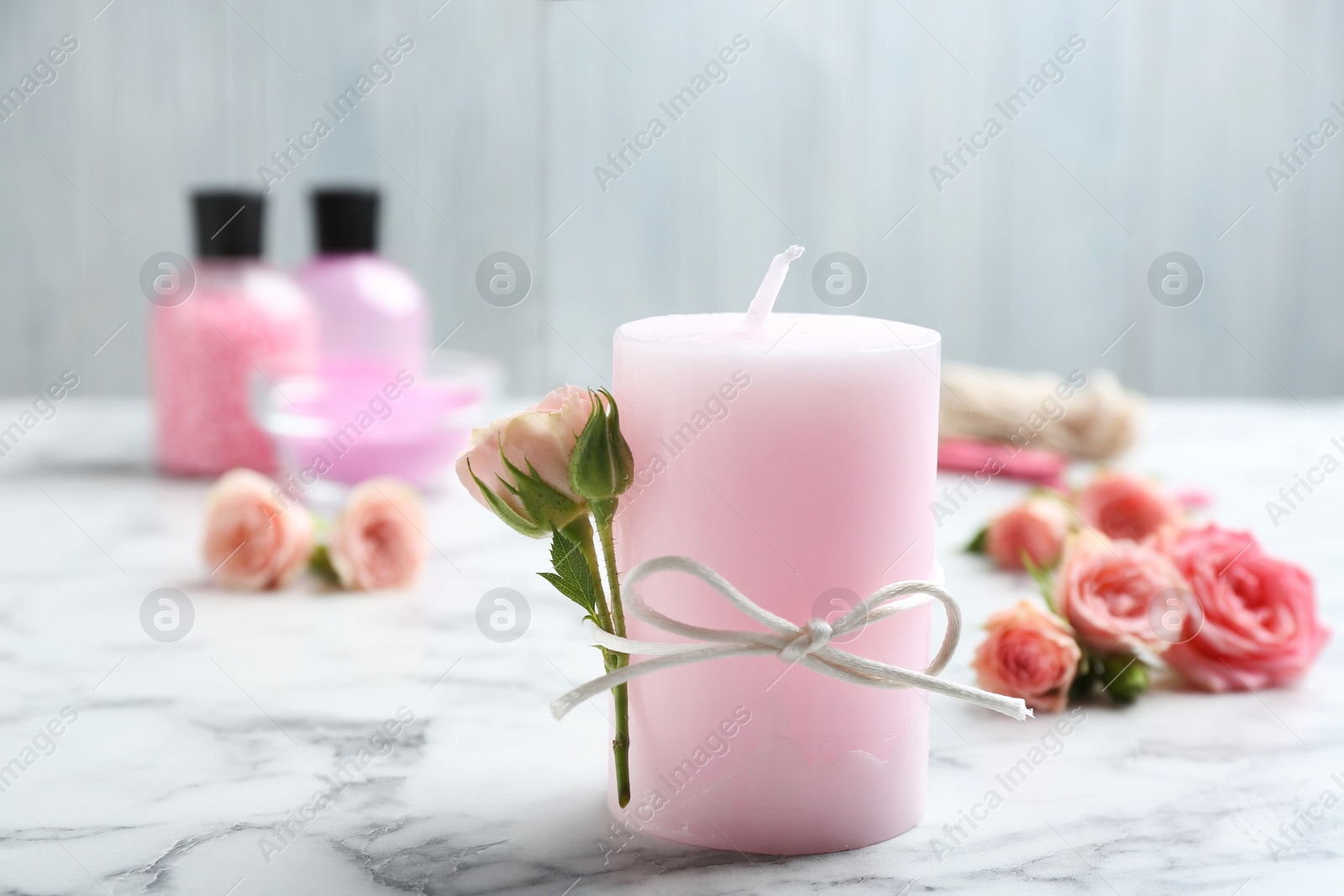 Photo of Scented candle with roses on marble table