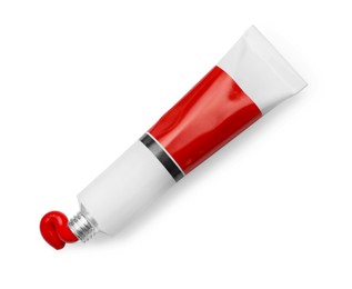 Tube with red oil paint on white background, top view