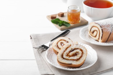 Tasty cake roll with jam on white wooden table, space for text