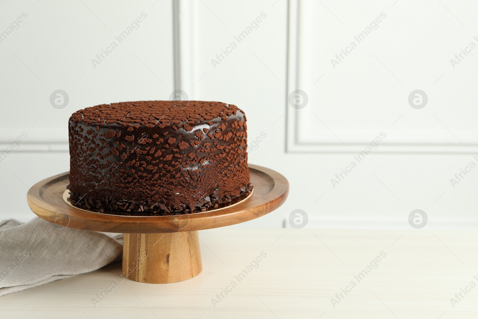 Photo of Delicious chocolate truffle cake on light wooden table, space for text