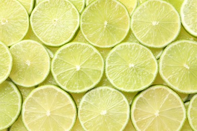 Photo of Fresh juicy lime slices as background, top view