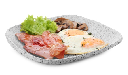 Photo of Plate with fried eggs, bacon, mushrooms and lettuce on white background