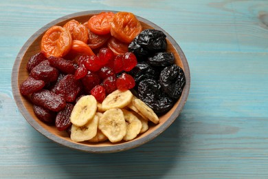 Photo of Mix of delicious dried fruits on light blue wooden table