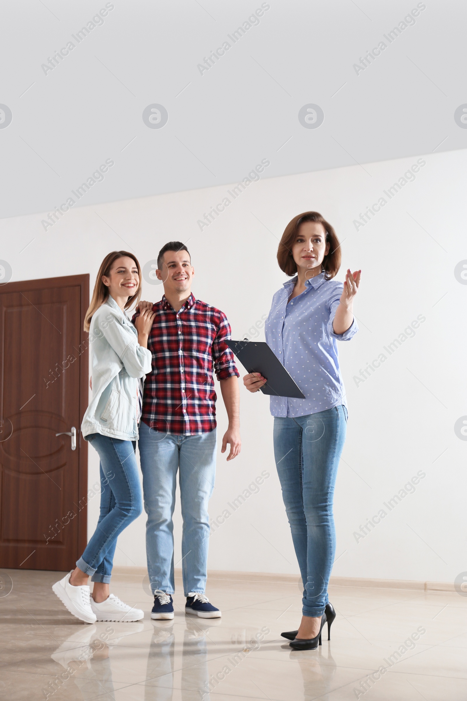 Photo of Real estate agent showing new apartment to young couple