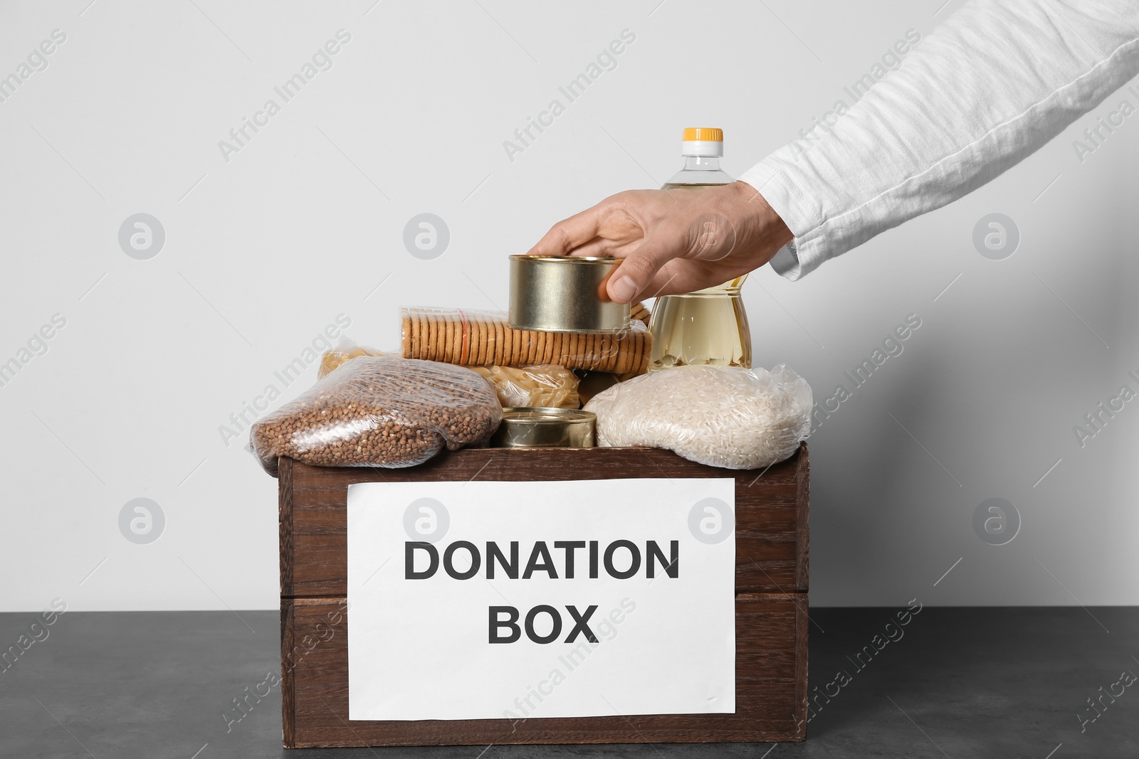 Photo of Male volunteer collecting food into donation box