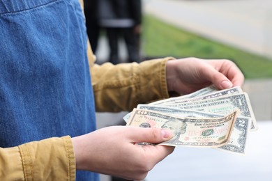 Photo of Waitress holding tips in outdoor cafe, closeup